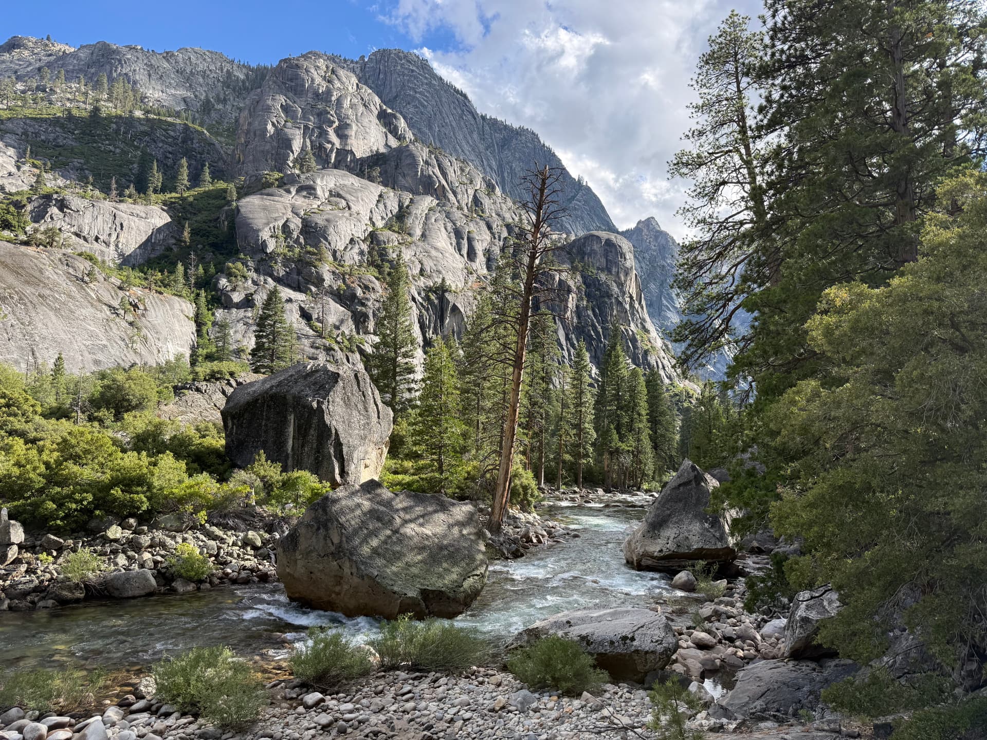 A river rushing through a granite canyon beneath towering gray cliffs
